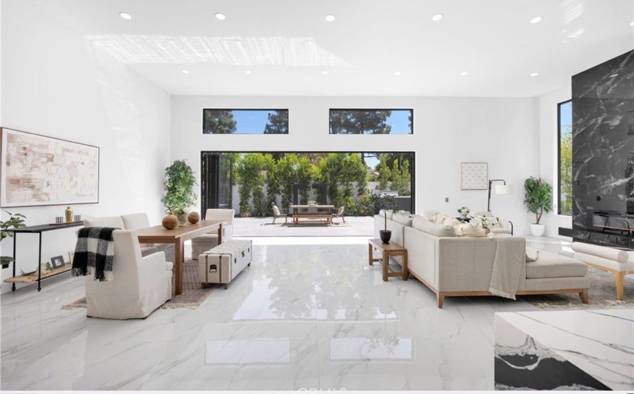 Finished great room — polished marble, vaulted volume.