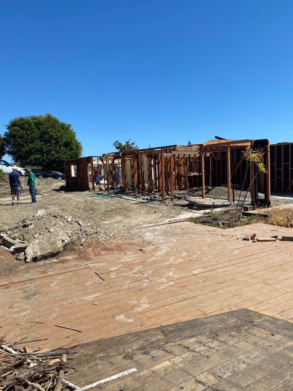 Site at early framing — slab cleared, walls going up.
